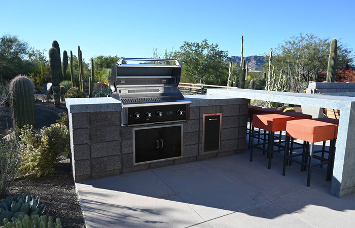 Wildfire Ranch Pro 36-inch grill in black stainless steel built into a stone outdoor kitchen island in an Arizona desert backyard