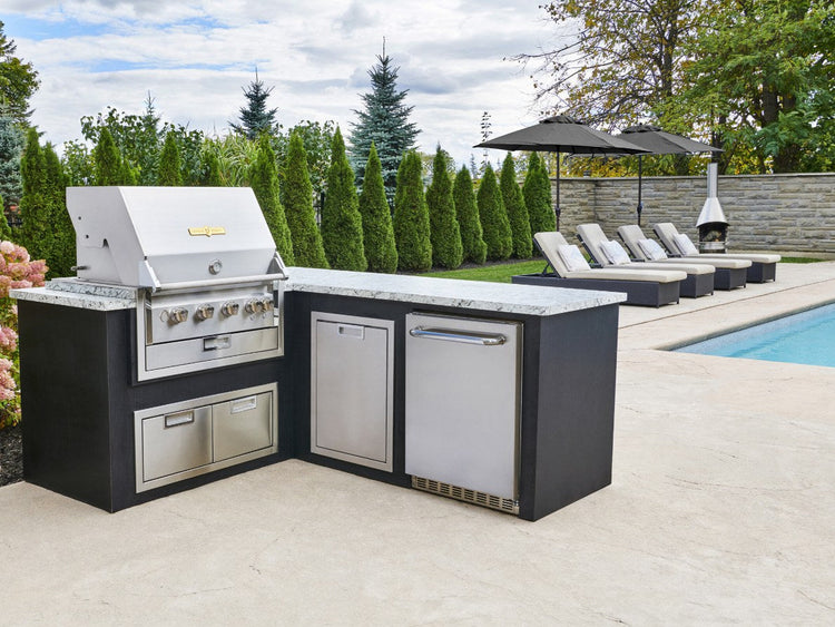 Crown Verity 24-inch outdoor refrigerator built into an L-shaped outdoor kitchen by a pool