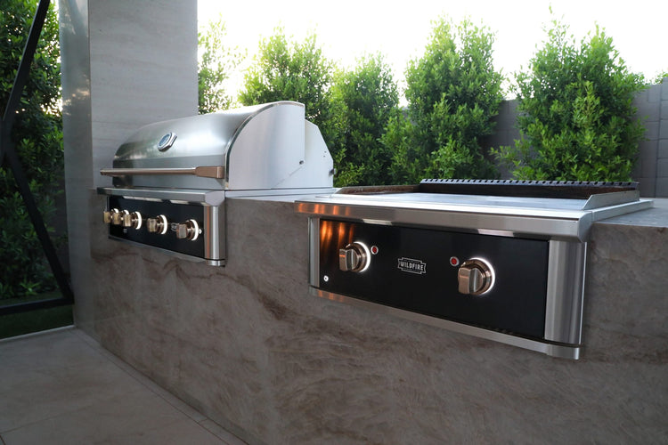Wildfire Ranch Pro 42-inch grill and 30-inch griddle in black stainless steel built into a stone island