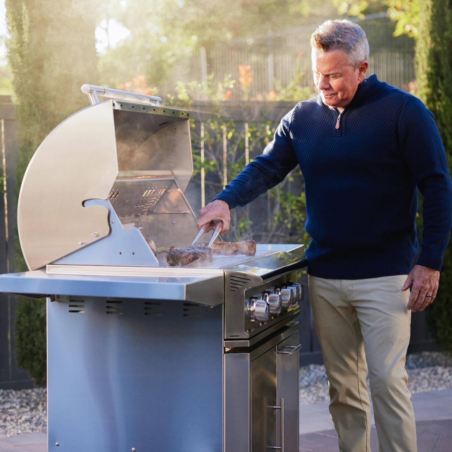 Man cooking on a Blaze Professional LUX freestanding gas grill outdoors