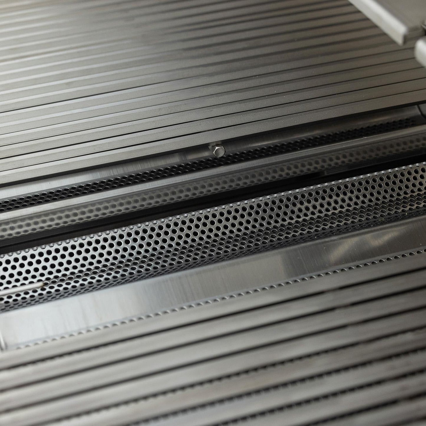 Close view of the hexagonal cooking grates and flame tamers